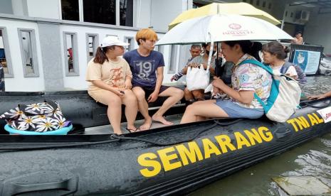 Personel TNI AL mengevakuasi warga yang rumahnya kebanjiran di Kota Semarang.