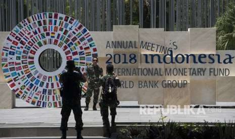 Personel TNI berfoto dengan latar belakang logo bendera berbagai negara di sekitar kawasan yang akan menjadi tempat berlangsungnya pertemuan tahunan IMF-Bank Dunia di Bali Nusa Dua Convention Center (BNDCC), Nusa Dua, Bali, Senin (1/10). 