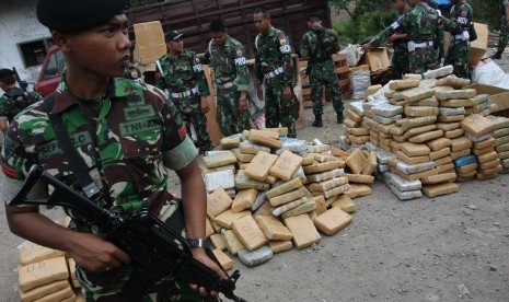 Personel TNI berjaga di samping barang bukti ganja kering yang diamankan, di Medan, Sumatera Utara, Jumat (10/7).  (Antara/Irsan Mulyadi)