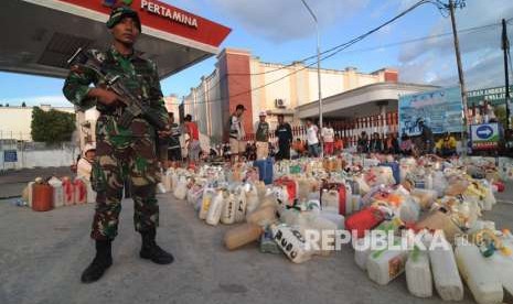 Personel TNI berjaga saat antrean BBM di salah satu SPBU di Palu, Sulawesi Tengah, Jumat (5/10).