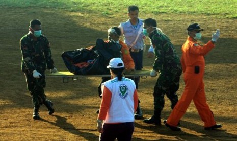 Personel TNI dan SAR mengangkat kantong jenazah korban pesawat Sukhoi Superjet 100 di helipad yang dibangun di kawasan Cijeruk, Bogor, Jawa Barat, Sabtu (12/5)