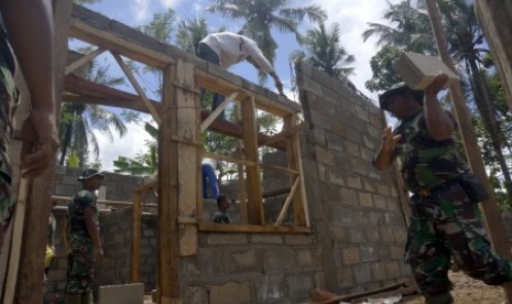 Personel TNI dari satuan Zeni Korem 081/DSJ Madiun melakukan rehabilitasi rumah korban terdampak bencana banjir bandang di Pacitan, Jawa Timur, Ahad (10/12). Sebanyak 420 unit dari total 6.603 rumah terdampak bencana banjir bandang dan tanah longsor daerah itu mulai dibangun bertahap dengan target tuntas Januari 2018. 