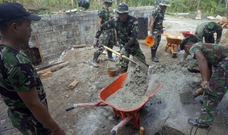 Personel TNI kerja bakti membangun rumah ibadah dalam rangkaian program TMMD (TNI Manunggal Masuk Desa). 