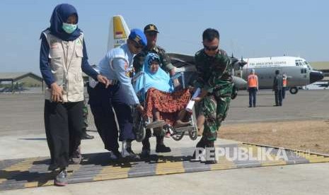 Personel TNI mengevakuasi korban gempa dan tsunami Palu-Donggala saat tiba di Lanud Hasanuddin, Makassar, Sulawesi Selatan, Senin (1/10). 