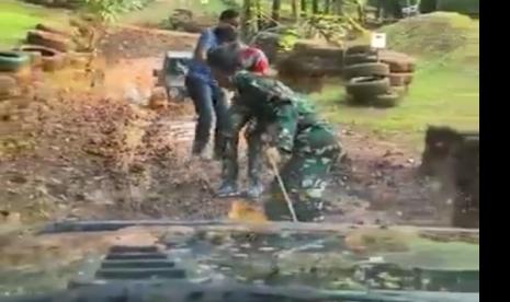 Personel TNI menggunakan tali tambang menarik mobil mogok, yang penumpang sipil di dalamnya malah tertawa.