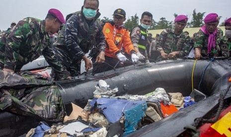 Personel TNI menuntun perahu yang berisi puing pesawat Lion Air JT 610 di perairan Karawang, Pantai Tanjung Pakis, Jawa Barat, Selasa (30/10/2018).