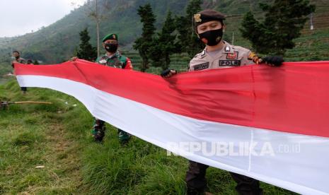 Personel TNI-Polri membentangkan bendera merah putih di telaga Cebong di dataran tinggi Dieng Desa Sembungan, Kejajar, Wonosobo, Jawa Tengah, Rabu (19/8/2020). Pembentangan bendera merah putih sepanjang 1.800 meter mengelilingi telaga di ketinggian 2.100 mdpl tersebut untuk memeriahkan HUT ke-75 Kemerdekaan Indonesia sekaligus sebagai wujud soliditas TNI-Polri dalam menjaga keutuhan NKRI.