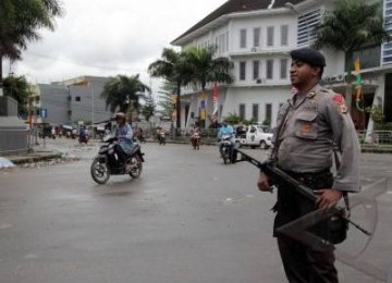 Personil Brimob Polda Maluku siaga mengamankan ruas jalan Dokter Sutomo yang terletak di pusat Kota Ambon, Senin (12/9). Ruas jalan tersebut mulai dinormalisasi menyusul kericuhan antar warga, Ahad  (11/9). 