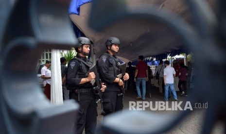   Personil Detasemen Gegana Polda Metro Jaya melakukan penjagaan di gerbang masuk Gereja Katedral, Jakarta Pusat, Jumat (25/3). (Republika/Rakhmawaty La'lang)