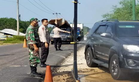 Personil di Posko Pelayanan Tanggap Darurat Pencegahan Penyebaran Virus Corona di Dusun I Desa Sukamaju Kecamatan Babat Supat, Kamis (25/6/2020), bersiaga melakukan pengawasan dan melakukan penyemprotan disinfektan kepada kendaraan roda dua dan roda empat yang melintas.