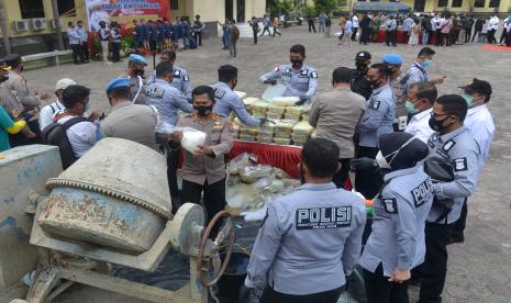 Personil Polda Aceh memasukan barang bukti tindak kejahatan narkotika jenis sabu ke dalam mesin molen dengan campuran semen dan air saat pemusnahan di Banda Aceh, Aceh, Rabu (10/3/2021). Sebanyak 404 kilogram narkotika jenis sabu asal Timur Tengah yang ditangkap Polda Aceh di perairan Selat Melaka bersama sembilan tersangka pada Januari 2021 tersebut dimusnahkan dengan cara diaduk dengan semen bercampur air menggunakan mesin molen.