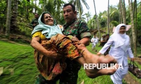 Personil prajurit Babinsa TNI jajaran Kodim 0103 Aceh Utara mengevakuasi warga sakit dan lumpuh dari kawasan terisolir pedalaman Lhok Tampu, Desa Panggoi, Lhokseumawe, Aceh. Senin (24/9). 