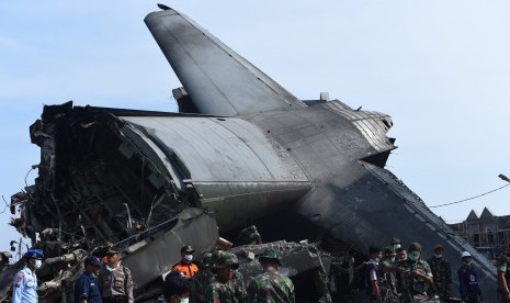 Personil TNI bersama Petugas PMI dan Basarnas melakukan evakuasi puing-puing pesawat Hercules C-130 yang jatuh di Jalan Jamin Ginting, Medan, Sumatera Utara, Rabu (1/7).