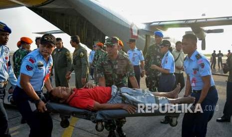 Personel TNI menandu korban luka bencana gempa dan tsunami Palu.