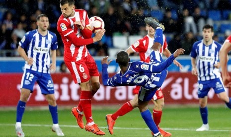 Pertandingan antara Alaves (putih biru) vs Girona (ilustrasi). Sebanyak 15 anggota klub Alaves positiv terinfeksi virus corona.(EPA)