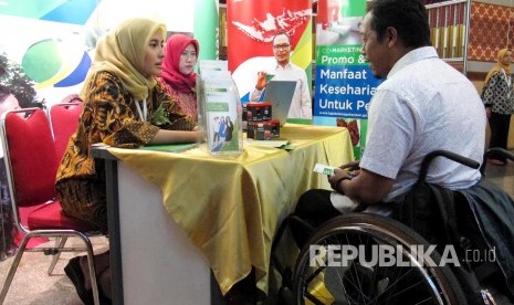 Pertugas BPJS Ketenagakerjaan berbincang dengan seorang penyandang disabilitas pada acara Gebyar Pemberian Manfaat Kepada Penyandang Disabilitas Se Provinsi Jawa Barat oleh BPJS Ketenagakerjaan, di Aula Pusdai, Kota Bandung, Selasa (8/8). 