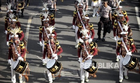 Pertunjukan marching band oleh taruna akademi kepolisian Cendrawasih saat mengikuti kirab 190 bendera negara peserta Sidang Umum Interpol ke-85 saat berlangsungnya hari bebas kendaraan bermotor di Jakarta, Ahad (29/10).