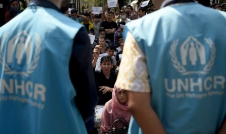 Perwakilan dari petugas dari kantor Badan Komisi Tinggi PBB untuk pengungsi (UNHCR) menemui pencari suaka sebelum dipindahkan dari trotoar kawasan Kebon Sirih, Jakarta, Kamis (11/7/2019). Pemerintah DKI Jakarta memindahkan pencari suaka yang berasal dari Afganistan, Somalia, Sudan dan Pakistan ke lahan bekas Markas Komando Distrik Militer (Makodim) Kalideres, Jakarta Barat. 