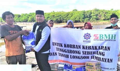 Perwakilan Laznas BMH menyerahkan bantuan kepada korban kebakaran dan longsor di Tenggarong.