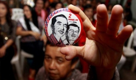 Perwakilan Orang Mini se-Indonesia memengang pin bergambar pasangan capres cawapres Jokowi-JK ketika menghadiri deklarasi dukungan Waria Jakarta untuk pasangan tersebut di Posko Relawan Rakyat Merah Putih, Jakarta, Sabtu (21/6).