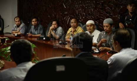 Perwakilan pengelola situs Islam mendengarkan juru bicara Badan Nasional Penanggulangan Bencana Terorisme (BNPT), Irfan Idris (kiri), Staff Ahli bid komunikasi media Hendry Subiakto berbicara saat konferensi pers usai rapat koordinasi di kantor Kominfo, Ja