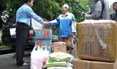 Perwakilan PT. Republika Media Mandiri (kiri) memberikan bantuan secara simbolik kepada pihak panitia Posko komplek kalibata H. Marhusin (kanan) di Posko bencana kelurahan Rawajati,Pancoran, Jakarta Selatan, Kamis (17/1)