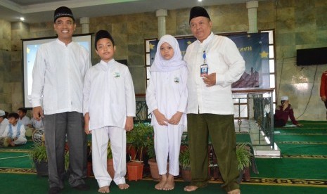 Perwakilan santri dan santriwati menerima pin yang disematkan oleh  Wadir Dikdasmen Sekolah Bosowa Bina Insani (SBBI), Sudirman, dan  Kepala SD Bosowa Bina Insani, M Sudrajat.