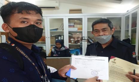 Perwakilan Tim Hukum Advokasi Pemilu Bersih 2024, Ibnu Syamsu (kiri) menyerahkan surat somasi kepada staf bagian persuratan KPU RI di Kantor KPU RI, Jakarta, Selasa (13/12). Tim hukum ini mensomasi KPU RI terkait dugaan kecurangan dalam tahap verifikasi faktual partai politik calon presiden Pemilu 2024. 