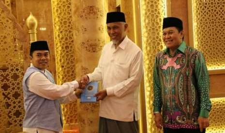 Perwakilan Yayasan Almanarah untuk Wilayah Sumbar  H Mulyadi Muslim Lc, MA (kiri)  menyerahkan wakaf Alquran secara simbolis kepada Wali Kota Padang, Mahyeldi Ansharullah.