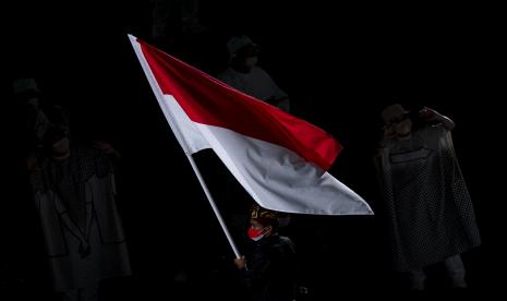 Peselancar Indonesia Rio Waida membawa bendera Merah-Putih saat defile pembukaan Olimpiade Tokyo 2020 di Stadion Nasional, Tokyo, Jepang, Jumat (23/7/2021)