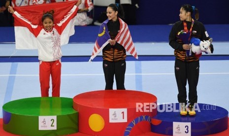 Pesenam Indonesia Rifda Irfana Luthfi (kiri) menbentangkan Bendera Merah Putih pada upacara penganugerahan medali Senam Artistik SEA Games ke-30 di Rizal Coliseum Stadion RSMC Nino Aquino, Manila, Filipina, Senin (2/12/19).