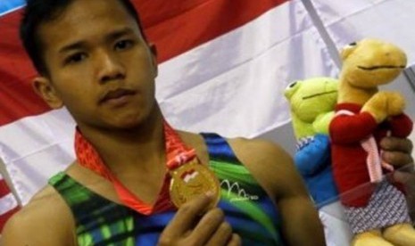 Pesenam Indonesia, Muhammad Try Saputra menunjukkn medali emas yang diperoleh dari final senam artistik final perorangan alat palang tunggal SEA Games XXVI di GOR Ranau, Jakabaring Sport Center (JSC), Palembang, Sumsel, Selasa (15/11).