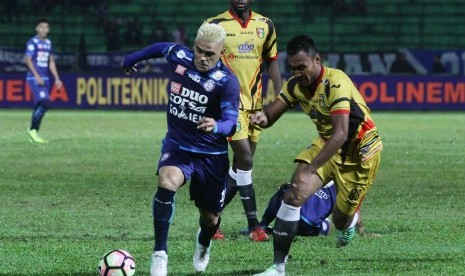 Pesepak bola Arema FC Cristian Gonzales (kiri) berusaha melewati hadangan pesepak bola Mitra Kukar Seftia Hadi (kanan) dalam pertandingan Liga 1 di Stadion Gajayana, Malang, Jawa Timur, Ahad (28/5).