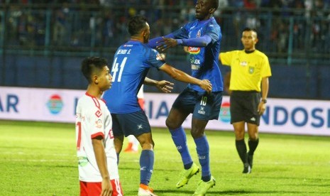 Pesepak bola Arema FC, Dendy Santosa (tengah) menyambut rekannya Makan Konate (kanan) yang mencetak gol di gawang Perseru Badak Lampung FC dalam pertandingan Liga I di Stadion Kanjuruhan, Malang, Jawa Timur, Selasa (16/7/2019). 