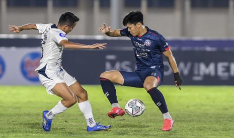 Pesepak bola Arema FC Feby Eka Putra (kanan) berebut bola dengan pesepak bola PSIS Semarang Finky Pasamba (kiri) dalam lanjutan Liga 1 2021-2022 di Stadion Madya Gelora Bung Karno, Jakarta, Sabtu (25/9/2021).