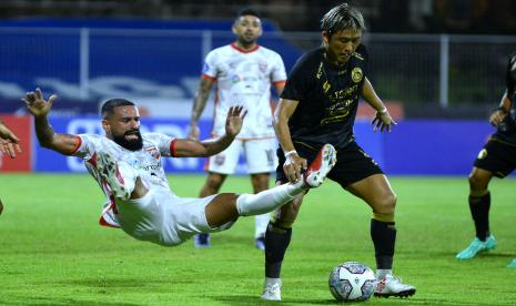 Pesepak bola Arema FC Renshi Yamaguchi (kanan) berebut bola dengan pesepak bola Borneo FC Fransisco Wagsley (kiri) saat pertandingan Liga 1 di Stadion I Gusti Ngurah Rai, Denpasar, Bali, Ahad (20/3/2022). Arema bermain imbang lawan Borneo FC dengan skor 2-2. 