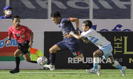 Pesepak bola Arema FC Rizky Dwi Febrianto (tengah) berebut bola dengan pesepak bola Persela Lamongan Riyatno Abiyoso (kanan) saat bertanding pada laga lanjutan BRI Liga 1 di Stadion Madya GBK, Senayan, Jakarta, Ahad (3/10/2021). Arema FC menang atas Persela Lamongan dengan skor 3-0. 