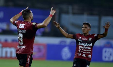 Striker Bali United Ilija Spasojevic (kiri) berselebrasi bersama rekannya Sidik Saimima (kanan) usai mencetak gol ke gawang PSS Sleman saat pertandingan Liga 1 di Stadion I Gusti Ngurah Rai, Denpasar, Bali, Rabu (16/2/2022). Bali United unggul 1-0 di laga itu.