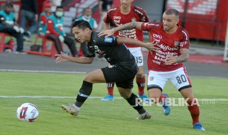 Pesepak bola Bali United Paulo Sergio (kanan) berebut bola dengan pesepak bola Madura United Syahrian Abimanyu (kiri) saat pertandingan Liga 1 2020 di Stadion Kapten I Wayan Dipta, Gianyar, Bali, Ahad (15/3/2020).