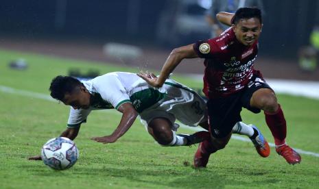 Pesepak bola Bali United Ricky Fajrin (kanan) berebut bola dengan pesepak bola PSS Sleman Bagas Umar (kiri) saat pertandingan Liga 1 di Stadion I Gusti Ngurah Rai, Denpasar, Bali, Rabu (16/2/2022).