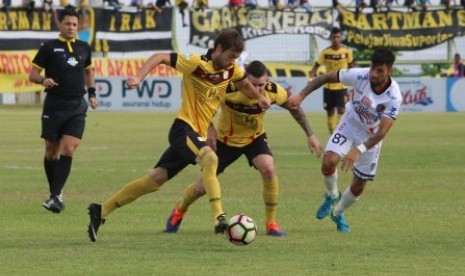 Pesepak bola Barito Putera Douglas Packer (kiri) menggiring bola dengan dikawal pesepak bola Bali United Stepano Lilipally (kanan) pada lanjutan Liga 1 di Stadion 17 Mei, Banjarmasin, Kalsel, Rabu (25/10). Kedua tim bemain imbang 1-1.