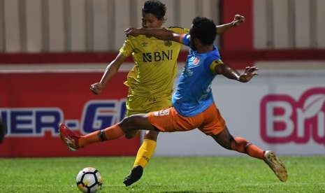 Pesepak bola Bhayangkara FC Adam Alis Setyono (kiri) berebut bola dengan pesepak bola Perseru Arthur Barrios Bonai (kanan) dalam laga lanjutan Liga 1 di Stadion PTIK, Jakarta, Rabu (12/9). Bhayangkara berhasil menang dengan skor 1-0. 