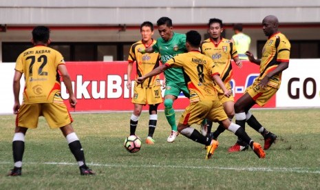 Pesepak bola Bhayangkara FC Alsan Putra Masat Sanda (tengah) menggiring bola melewati hadangan pesepak bola Mitra Kukar pada pertandingan Liga 1, di Stadion Patriot Candrabhaga, Bekasi, Jawa Barat, Jumat (21/7).