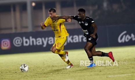 Pesepak bola Bhayangkara FC Flavio Beck Junior (kiri) berusaha melewati pesepak bola Tira Persibo Osas Saha (kanan) pada pertandingan lanjutan Liga 1 di Stadion Madya Gelora Bung Karno, Jakarta, Kamis (4/7/2019). 