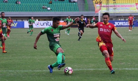 Pesepak bola Bhayangkara FC Lee Yujun (kanan) berusaha menghadang pesepak bola PS TNI Ahmad Nufian Dani (kiri) pada laga Gojek Traveloka Liga 1 di Stadion Patriot Candrabhaga, Bekasi, Jawa Barat, Sabtu (29/4). 