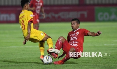 Pesepak bola Bhayangkara FC Muhamad Hargianto (kiri) berebut bola dengan pesepak bola Persija Jakarta Tony Sucipto. Tony menegaskan para pemain Persija tak terpengaruh perubahan venue final Piala Gubernur Jatim 2020 kontra Persebaya.