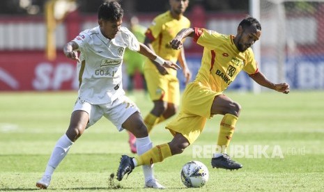 Pesepak bola Bhayangkara FC Muhammad Nur Iskandar (kanan) berebut bola dengan pesepak bola PSS Sleman Ocvian Chaniago (kiri) saat laga lanjutan Liga 1 di Stadion PTIK, Jakarta, Jumat (4/10/2019). 