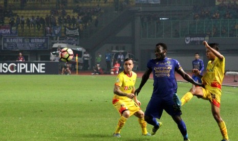 Pesepak bola Bhayangkara FC, Wahyu Sube Seto (kanan) berebut bola dengan pesepak bola Persib Bandung, Michael Essien (tengah) pada pertandingan Liga 1 di Stadion Patriot Candrabhaga, Bekasi, Jawa Barat, Ahad (4/6) malam. Bhayangkara FC menang dengan skor 2-0.