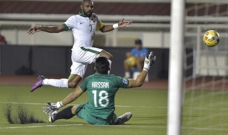 Pesepak bola Indonesia Boaz Solosa (kiri) melepaskan tendangan ke arah gawang Singapura yang dikawal Hassan Abdullah Sunny pada laga putaran final Grup A AFF Suzuki 2016 di Rizal Memorial Stadium, Manila, Filipina, Jumat (25/11).