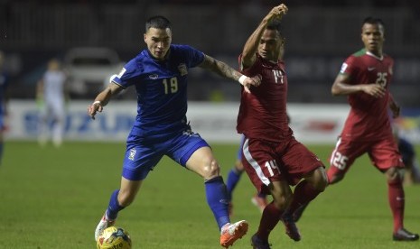 Pesepak bola Indonesia Risky Pora (tengah) berebut bola dengan pesepak bola Thailand Tristan Do pada laga putaran pertama final AFF Suzuki Cup 2016 di Stadion Pakansari, Kabupaten Bogor, Jabar, Rabu (14/12). 